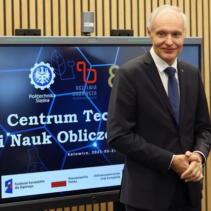 Mężczyzna w garniturze przedstawia logo Centrum Technologii i Nauk Obliczeniowych Politechniki Śląskiej. (wygenerowano przez AI)