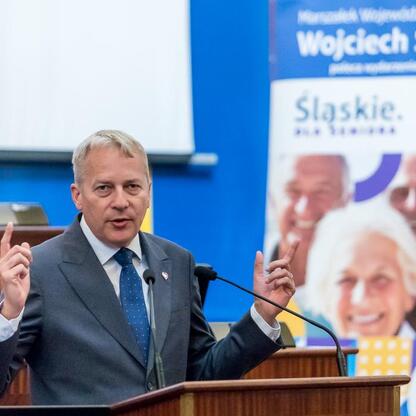 Marszałek Wojciech Saługa przemawia na forum o seniorach w Silesia dla Seniorów. (wygenerowano przez AI)