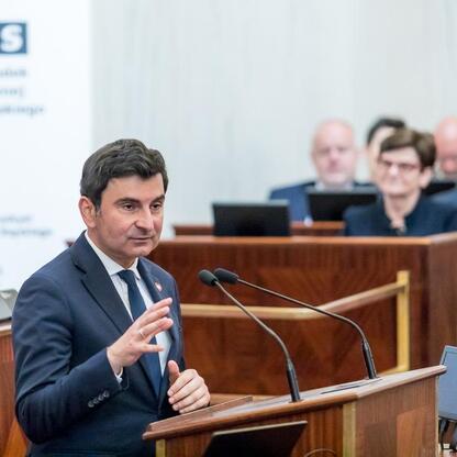Sylwetka wydarzenia w Sali Sejmu Śląskiego, gdzie marszałek Saługa przemawia do seniorów. (wygenerowano przez AI)