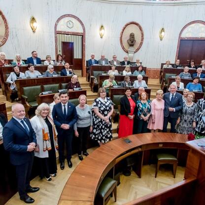 Wojciech Saługa, Marszałek Województwa Śląskiego, prowadzi forum o Uniwersytetach Trzeciego Wieku w Sali Sejmowej Śląskiej. (wygenerowano przez AI)