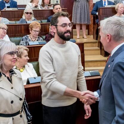Sylwetka uczestników w Sali Sejmu Śląskiego podczas uroczystości związanych z Uniwersytetami Trzeciego Wieku. (wygenerowano przez AI)