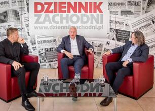 Na zdjęciu widoczny jest mężczyzna w garniturze, który dyskutuje o przyszłości edukacji i nauki w regionie Śląskim. (wygenerowano przez AI)
