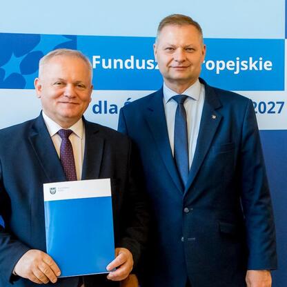 Członkowie Zarządu Województwa Śląskiego Rafał Adamczyk i Marcin Ryś wręczają listy gratulacyjne beneficjentom projektów edukacyjnych finansowanych z Funduszy Europejskich dla Śląska 2021-2027. (wygenerowano przez AI)