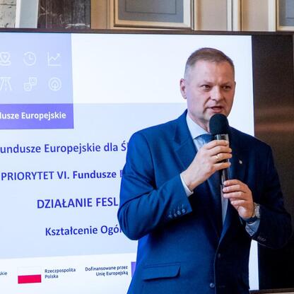 Rafał Adamczyk, członek Zarządu Województwa Śląskiego, przemawia o inwestycjach w edukację. (wygenerowano przez AI)