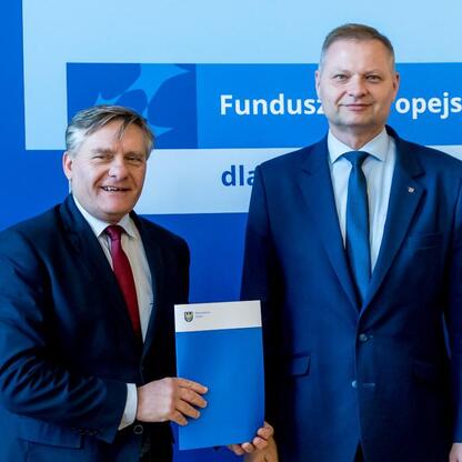 Rafał Adamczyk i Joanna Bojczuk wręczają listy gratulacyjne beneficjentom programu Fundusze Europejskie dla Śląska 2021-2027. (wygenerowano przez AI)