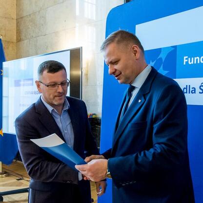 Rafał Adamczyk i Marcin Ryś wręczają listy gratulacyjne beneficjentom projektów edukacyjnych w ramach programu 