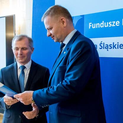 Rafał Adamczyk i Marcin Ryś wręczają listy gratulacyjne beneficjentom projektów edukacyjnych w ramach programu Fundusze Europejskie dla Śląska 2021. (wygenerowano przez AI)