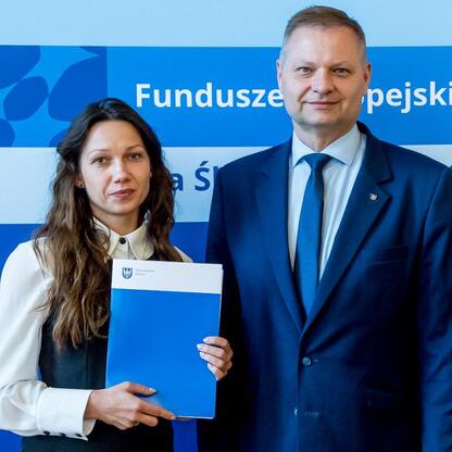 Rafał Adamczyk i Joanna Bojczuk prezentują dokumenty, związane z programem Fundusze Europejskie dla Śląska 2021-2027. (wygenerowano przez AI)