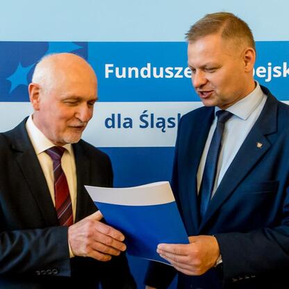 Członkowie Zarządu Województwa Śląskiego wręczają listy gratulacyjne beneficjentom grantu na edukację. (wygenerowano przez AI)
