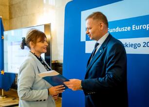 Joanna Bojczuk i Rafał Adamczyk wręczają listy gratulacyjne beneficjentom projektów edukacyjnych w ramach Funduszy Europejskich dla Śląska 2021-2027. (wygenerowano przez AI)