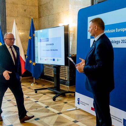 Członek Zarządu Województwa Śląskiego Rafał Adamczyk i inny uczestnik w szczytnym spotkaniu o Fundusze Europejskie 2021-2027. (wygenerowano przez AI)