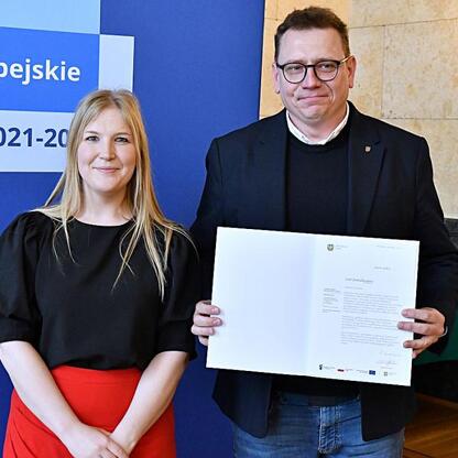 Joanna Bojczuk i Rafał Adamczyk prezentują dokumenty z Europejskiego Funduszu 2021-2027. (wygenerowano przez AI)