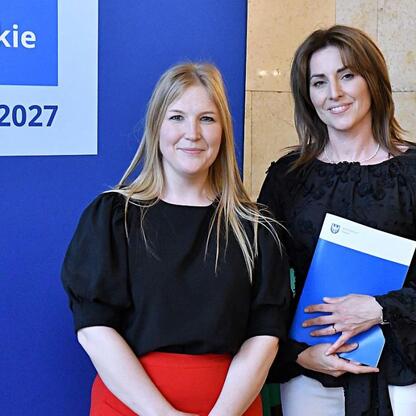 Joanna Bojczuk i Rafał Adamczyk wręczają listy gratulacyjne za projekty finansowane z Europejskich Funduszy 2021-2027 w Śląsku. (wygenerowano przez AI)
