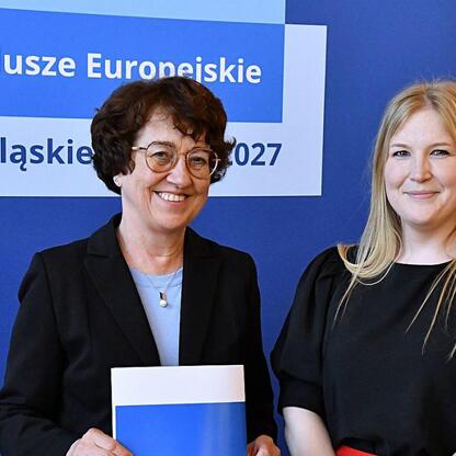Dwie kobiety przedstawiają dokumenty, promując Europejskie Fundusze dla Śląska 2027. (wygenerowano przez AI)