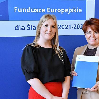 Joanna Bojczuk i Rafał Adamczyk wręczają listy gratulacyjne beneficjentom projektów edukacyjnych w ramach Funduszy Europejskich dla Śląska 2021-2027. (wygenerowano przez AI)