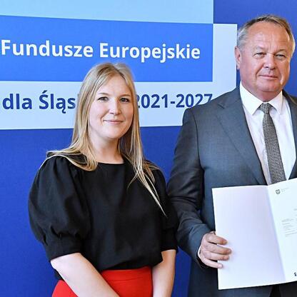 Joanna Bojczuk i Rafał Adamczyk przedstawiają projekt dofinansowania edukacji w ramach Funduszy Europejskich dla Śląska 2021-2027. (wygenerowano przez AI)