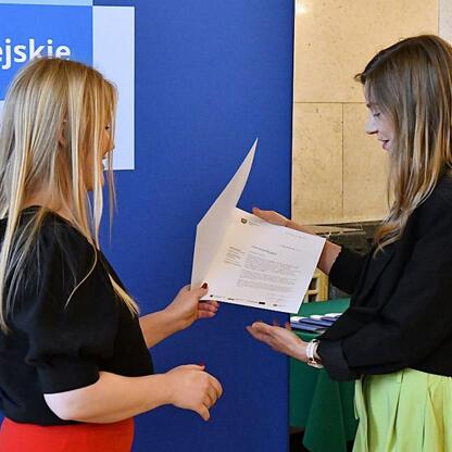 Dwie kobiety wymieniają dokumenty na tle 