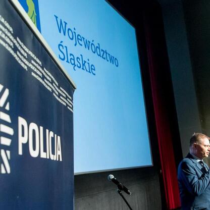 Rafał Adamczyk, członek Zarządu Województwa Śląskiego, przemawia na seminarium o bezpieczeństwie drogowym i cyberbezpieczeństwie. (wygenerowano przez AI)