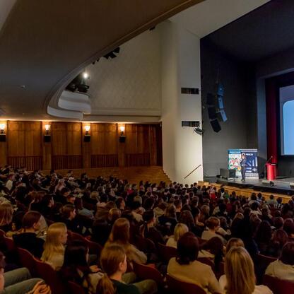 Lecture hall filled with attentive students at Pałac Kultury Zagłębia in Dąbrowa Górnicza, discussing road safety and harassment. (wygenerowano przez AI)