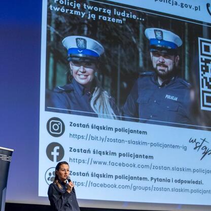 Na scenie stoi kobieta z mikrofonem, promującą dołączenie do Silesian Police. (wygenerowano przez AI)