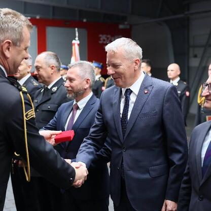 Wojciech Saługa i Grzegorz Boski wręczają medale strażakom w Częstochowie. (wygenerowano przez AI)