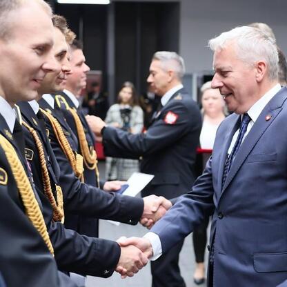 Wojciech Saługa, Marszałek Województwa Śląskiego, spotyka się z oficerami w mundurze, omawiając inwestycje w regionie. (wygenerowano przez AI)