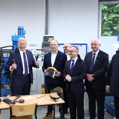 Grupa oficjalnych wizytujących inspekcję modernizacji CNC w regionie Śląskim. (wygenerowano przez AI)