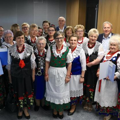 Grupa kobiet w tradycyjnych strojach z Silesia, uczestniczących w regionalnym konkursie wspierającym lokalne grupy kobiet. (wygenerowano przez AI)