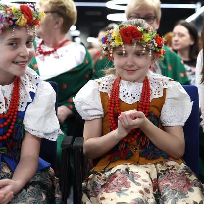 Grupa ludzi w tradycyjnych strojach na konferencji w Stadionie Śląskim. (wygenerowano przez AI)