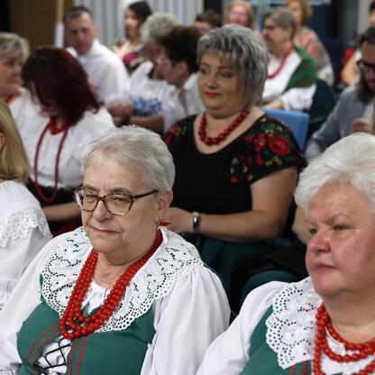 Grupa kobiet w tradycyjnych strojach uczestniczy w konferencji o kulturze lokalnej. (wygenerowano przez AI)