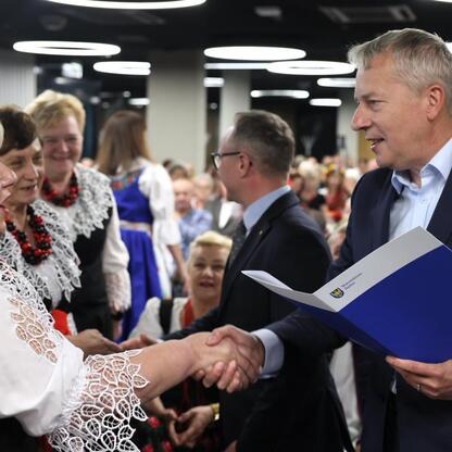 Wojciech Saługa, Marszałek Województwa Śląskiego, wręcza gratulacje na konferencji w Śląskim Stadionie. (wygenerowano przez AI)