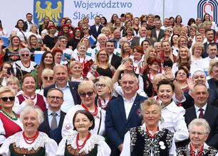 Grupa ludzi w tradycyjnych strojach na Stadionie Śląskim podczas uroczystości wsparcia dla kół gospodyń wiejskich. (wygenerowano przez AI)