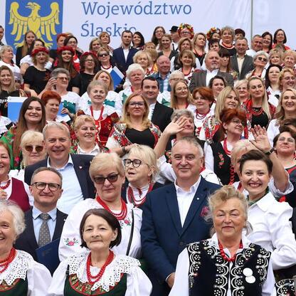 Grupa ludzi w tradycyjnych strojach na Stadionie Śląskim, wspieranie kół gospodyń wiejskich. (wygenerowano przez AI)