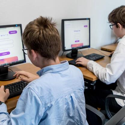 Dwa uczniowie pracują na komputerach w klasie, oceniane w ramach IT Fitness Test. (wygenerowano przez AI)