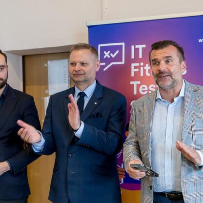 Trzech mężczyzn w czarnych garniturach przedstawiających IT Fitness Test, organizowany przez Rafała Adamczyka, członka Zarządu Województwa Śląskiego. (wygenerowano przez AI)