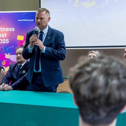 Członek Zarządu Województwa Śląskiego Rafał Adamczyk przemawia na podium podczas IT Fitness Test 2025. (wygenerowano przez AI)