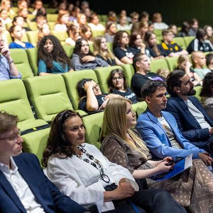 Audience listens attentively to a presentation on road safety and youth issues in Katowice. (wygenerowano przez AI)