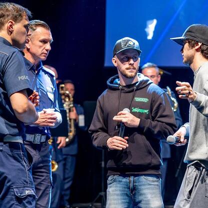 Grupa policjantów w Katowicach omawia bezpieczeństwo drogowe z młodymi ludźmi. (wygenerowano przez AI)