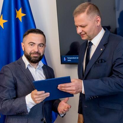 Rafał Adamczyk, Członek Zarządu Województwa Śląskiego, prezentuje dokumenty na inauguracji Wojewódzkiego Rynku Pracy w Katowicach. (wygenerowano przez AI)
