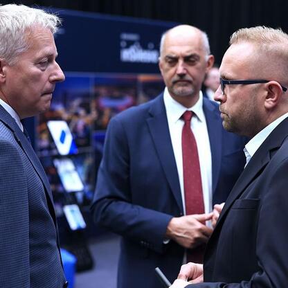 Wojciech Saługa, Marszałek Województwa Śląskiego, omawia regionalne wyzwania z Marcinem Ryśem i innymi uczestnikami Business Mixer w Jaworznie. (wygenerowano przez AI)