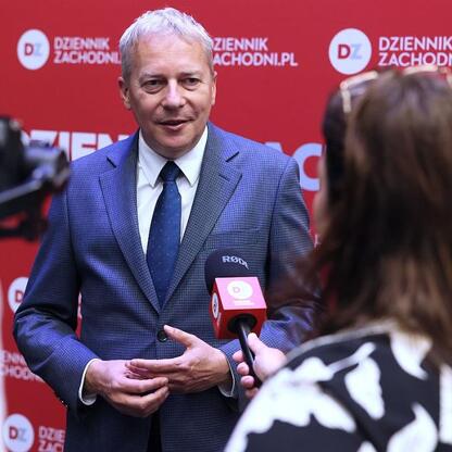 Marszałek Województwa Śląskiego Wojciech Saługa w rozmowie z dziennikarką podczas Business Mixer w Jaworznie. (wygenerowano przez AI)