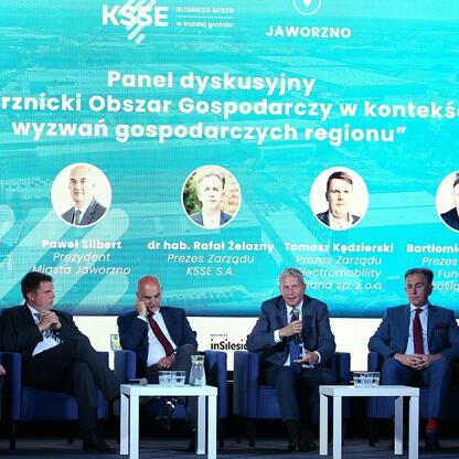 Panel dyskusyjny podczas Business Mixer w Jaworznie, organizowany przez KSSE, skupiający się na potencjale Jaworzna jako kluczowego punktu inwestycyjnego w regionie. (wygenerowano przez AI)