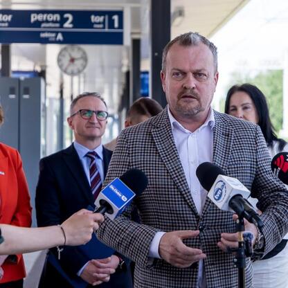 Wicemarszałek Województwa Śląskiego Grzegorz Boski i lokalni urzędnicy omawiają nowe połączenia kolejowe w Dąbrowie Górniczej. (wygenerowano przez AI)