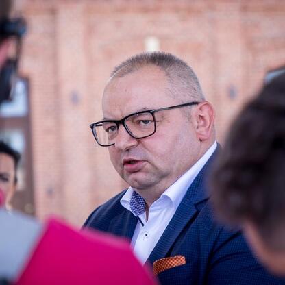 Zdjęcie przedstawia konferencję prasową w Dąbrowie Górniczej, związana z uruchomieniem nowych połączeń kolejowych między Częstochową a Krakowem, a także inwestycjami w regionalny transport województwa (wygenerowano przez AI)