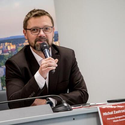 Michał Zastrzeżyński, wiceprezydent Sosnowca, przemawia na konferencji prasowej w Sosnowcu. (wygenerowano przez AI)