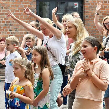 Ludzie uczestniczą w aktywnym wydarzeniu na festiwalu INDUSTRIADY, święcie przemysłowej dziedzictwa Śląska. (wygenerowano przez AI)