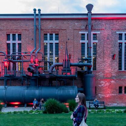 Festiwal INDUSTRIADY w Silesia: czerwone oświetlenie, przemysłowe instalacje, ludzie cieszący się festiwalem. (wygenerowano przez AI)