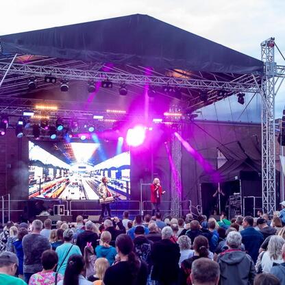 Fotografia przedstawiająca zakończenie festiwalu INDUSTRIADY, zorganizowanego w Zabytkowej Kopalni Ignacy, z koncertem i uroczystym wyduszaniem balonów. (wygenerowano przez AI)