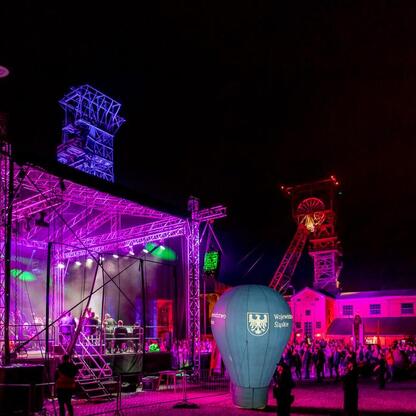 Zabytkowa Kopalnia Ignacy w Rybniku, oświetlona nocą, podczas finału festiwalu INDUSTRIADY. (wygenerowano przez AI)