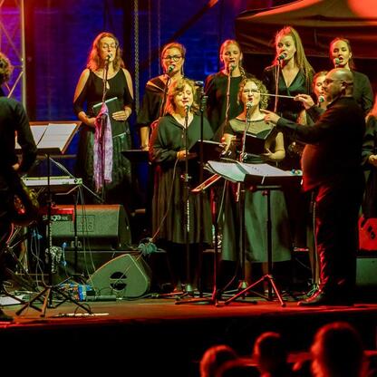 Zdjęcie przedstawia scenę z festiwalu INDUSTRIADY, gdzie artysta gra na saksofonie podczas koncertu na scenie w Zabytkowej Kopalni Ignacy. (wygenerowano przez AI)